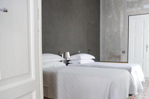 San Giuseppe VesuvianoRaphaëlle Relais的卧室内的两张床,配有白色床单和枕头