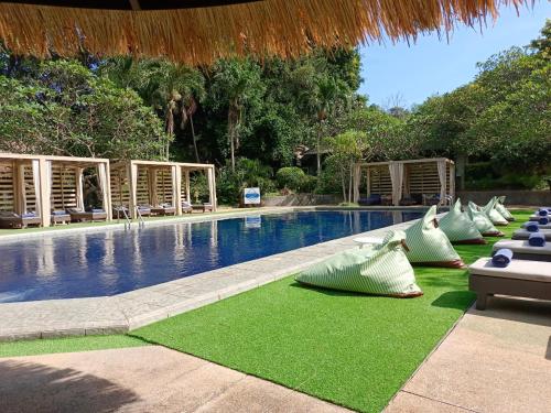 北芭堤雅Let's Hyde Pattaya Resort & Villas - Pool Cabanas的毗邻度假酒店的带躺椅和椅子的游泳池