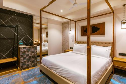 海得拉巴Avana- A Boutique Hotel的一间带四柱床的卧室和一间浴室
