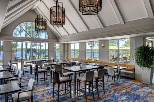巴拿马城海滩Bluegreen's Bayside Resort and Spa at Panama City Beach的用餐室设有桌椅和窗户。