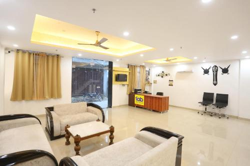 新德里FabExpress Taj Residency的带沙发和吊扇的等候室