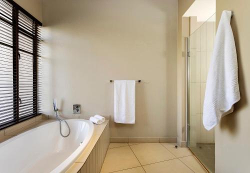 莫科帕内Sofala Lodge的白色的浴室设有浴缸和淋浴。