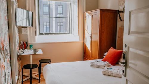 都柏林加德纳之家旅舍的小房间设有床和窗户