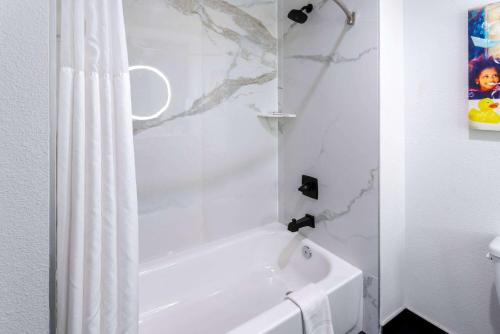 MaricopaLa Quinta Inn & Suites by Wyndham Maricopa Copper Sky的浴室内设有带浴帘的白色浴缸