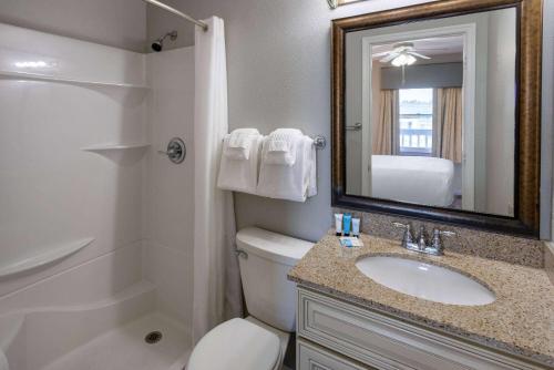 默特尔比奇Sea Mystique Resort的一间带卫生间、水槽和镜子的浴室