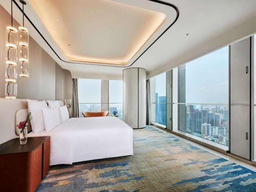 深圳深圳深铁铂尔曼酒店的卧室设有白色的床和大窗户