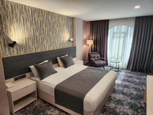 乔尔卢Yeşilyurt Park Otel的酒店客房带一张大床和一把椅子