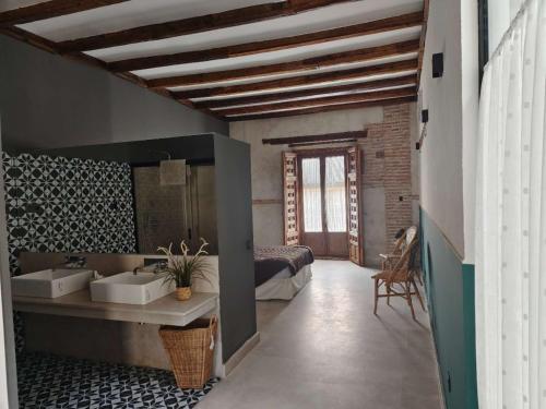 阿尔卡拉德荷那利斯Casa de los Mendoza - Casa Solariega en el casco histórico的一间带两个盥洗盆的浴室和一张位于客房内的床。