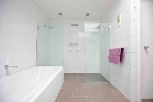 霍巴特Central Hobart - Beautiful Apartment的白色的浴室设有浴缸和淋浴。