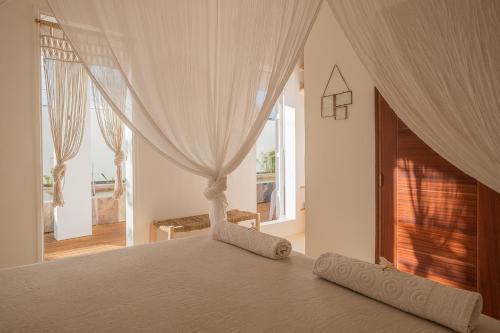 圣皮埃尔La Kazaka Terre Sainte的一间卧室配有带窗帘的床和窗户