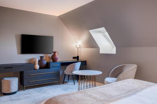 布鲁瓦Fleur de Loire的一间卧室配有电视、书桌和椅子