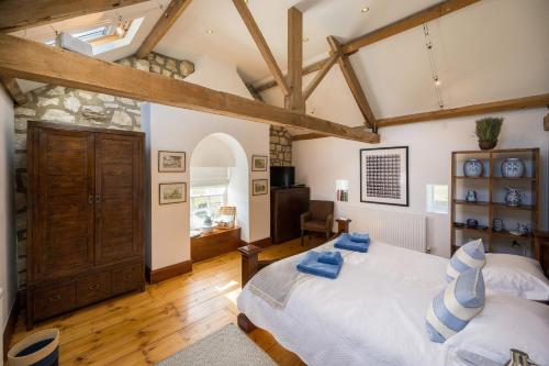 CopgroveCrow House Barn的一间卧室设有一张大床和木梁。