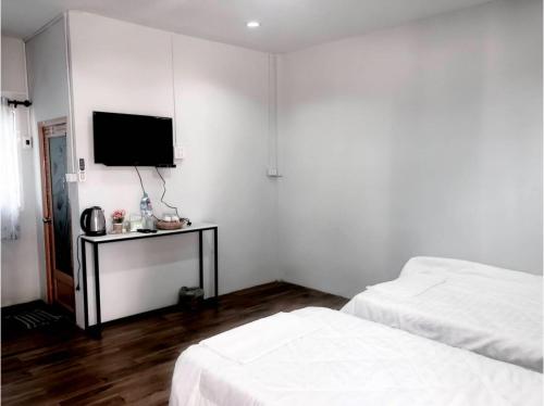 坤西育府Capital O 75412 V Resort的一间卧室设有两张床,墙上配有电视。