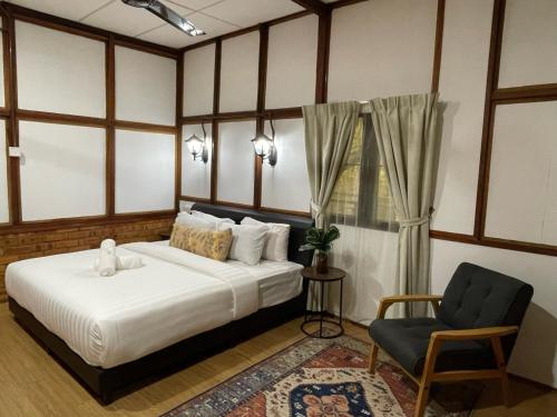 立咯海滩Api-api Eco Chalet的一间卧室配有一张床、一把椅子和窗户。