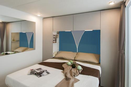 拉齐塞Piani di Clodia Holidaypark的一间卧室配有两张床和镜子