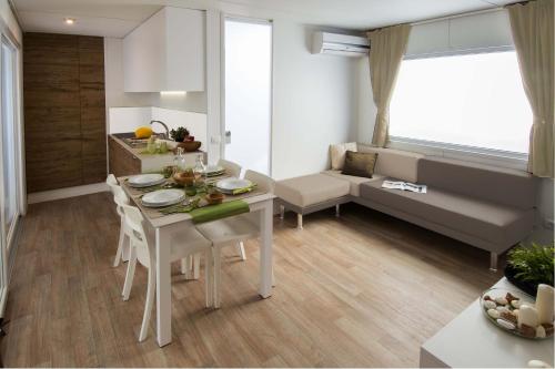 拉齐塞Piani di Clodia Holidaypark的厨房以及带桌椅的起居室。