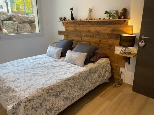 克松吕-隆日梅Les écureuils的一间卧室配有一张带木制床头板的床