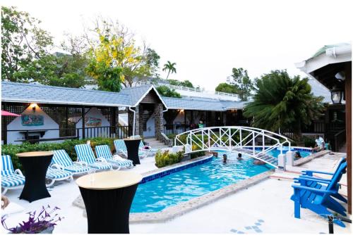 Port ElizabethSpring Hotel Bequia的度假村的游泳池,带椅子和桥梁