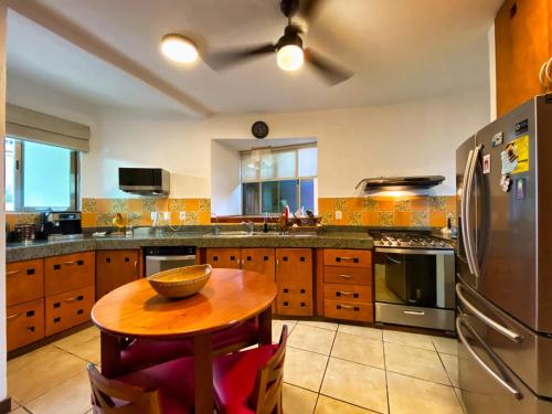 坎昆Humant Coliving - Cancún的厨房配有木桌和冰箱。