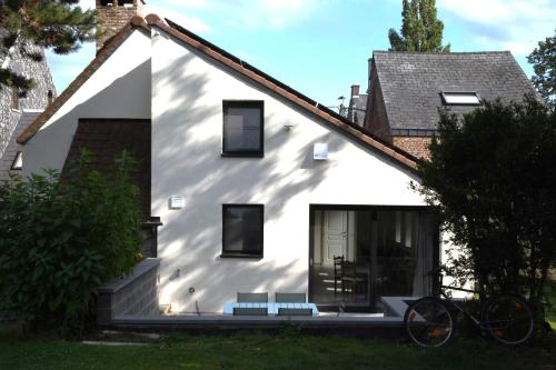 那慕尔Au four et au jardin的前面有两长椅的白色房子