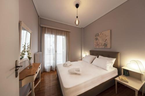雅典Spacious 3 Bedroom apt near Acropolis museum的卧室配有一张白色大床和一张书桌