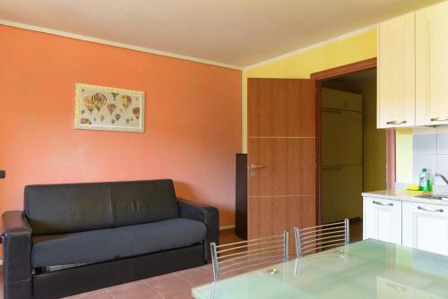 普拉托讷沃斯Capanna的一间带黑色沙发的客厅和一间厨房
