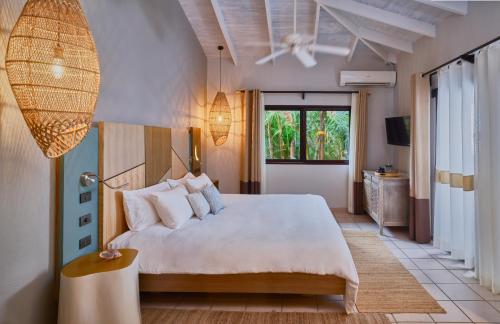 塔马林多卡拉鲁纳精品别墅酒店的卧室设有一张白色大床和一扇窗户。
