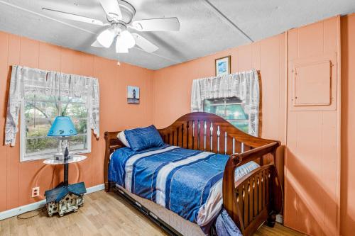 大西洋滩Fanci's Hideout的一间卧室设有橙色的墙壁、一张床和吊扇。