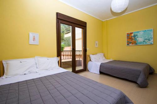 波塞蒂Beachfront Villa Posidi的黄色墙壁客房的两张床