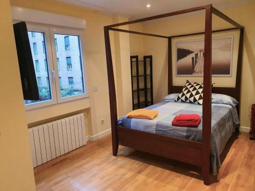 马德里LUXURY HOUSE-HERMOSA VIVIENDA LUJO-APPART DE LUXE的一间卧室配有一张天蓬床和两张毛巾