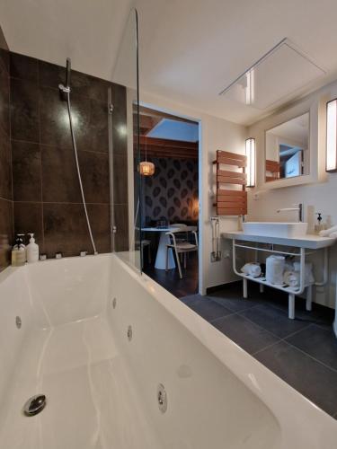 伊芙尔莱韦克Domaine de l'Epau Eco-Resort - Eco-Lodges的带浴缸和盥洗盆的大浴室