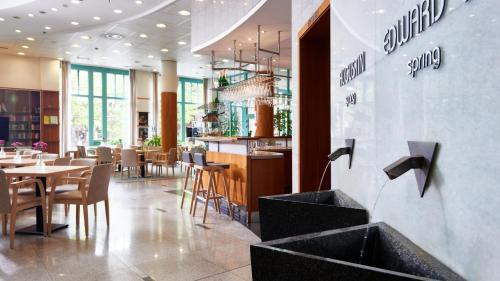 玛丽亚温泉OREA Spa Hotel Cristal的一间带桌椅的餐厅和一间酒吧
