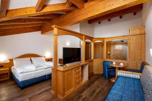 博萨迪法萨Hotel Terme Antico Bagno的一间酒店客房,配有一张床和一台电视