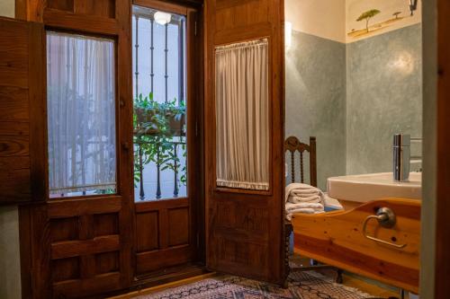 托莱多Casa Palacio Rincón de la Catedral的一间带水槽和浴缸的浴室以及窗户。
