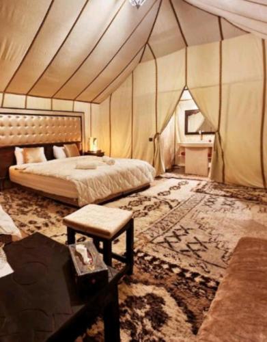 梅尔祖卡Luxury Desert Camp的帐篷内一间卧室,配有一张床