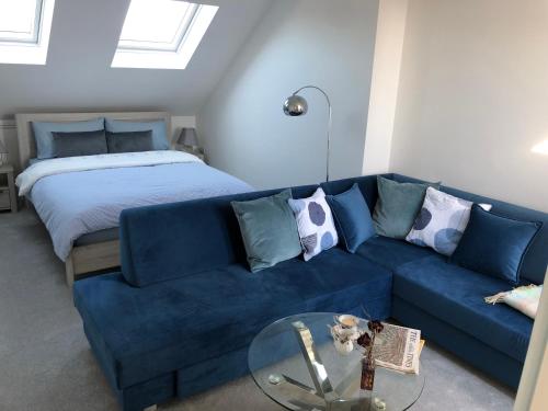 清福德Ainslie Loft in Chingford, London的客厅配有蓝色的沙发和床。