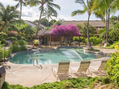 维雷亚Tropical Maui Kamaole B-Bldg的一个带椅子的游泳池,棕榈树