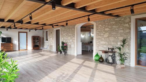 维罗纳Agriturismo Ponte Florio的客厅设有石墙和木制天花板