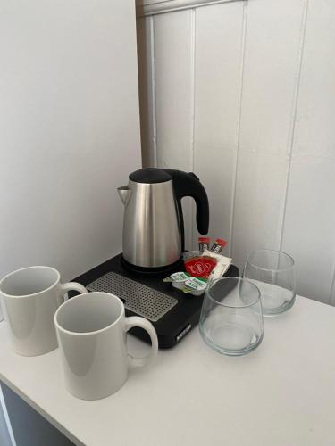 WylamShip Inn Stays Ltd的两个咖啡杯和两个杯子在柜台上