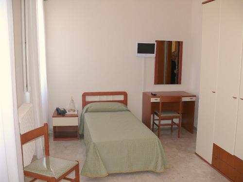 圣安吉罗山佩莱格里诺酒店的一间卧室配有一张床、一张桌子和一把椅子