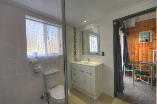 金德拜恩阿卡西亚雪汽车旅馆的一间带卫生间、水槽和镜子的浴室