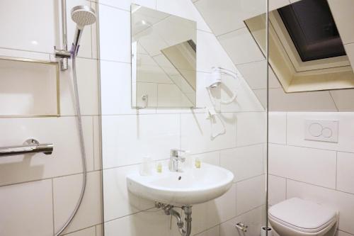 汉诺威JJ Hotel Hannover-City-Pension的白色的浴室设有水槽和卫生间。
