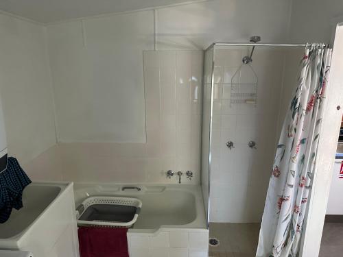 Patonga BeachPatonga Holiday Home的白色的浴室设有浴缸和淋浴。
