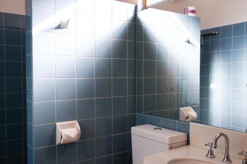 昆比恩昆比恩中部城市汽车旅馆的蓝色瓷砖浴室设有卫生间和水槽