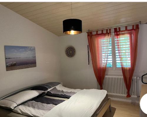 AsuelMaison chez Louis的一间卧室配有床和红色窗帘的窗户