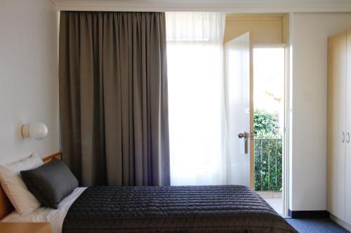 昆比恩昆比恩中部城市汽车旅馆的一间卧室设有一张床和一个大窗户