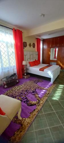姆特瓦帕Stars Maisonette的一间卧室配有一张床和紫色地毯