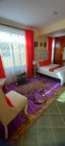 姆特瓦帕Stars Maisonette的一间卧室配有一张床和紫色地毯