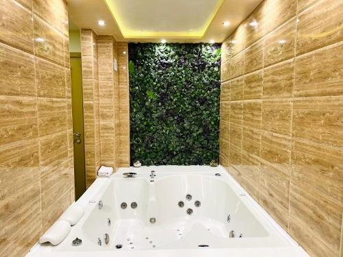 兹拉蒂博尔Apartmani SLEEP&JOY的带浴缸的浴室和绿色的墙壁