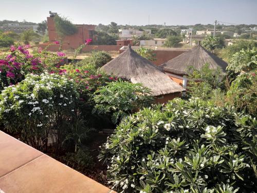 PoponguineBelle villa的享有花园鲜花和屋顶的景色